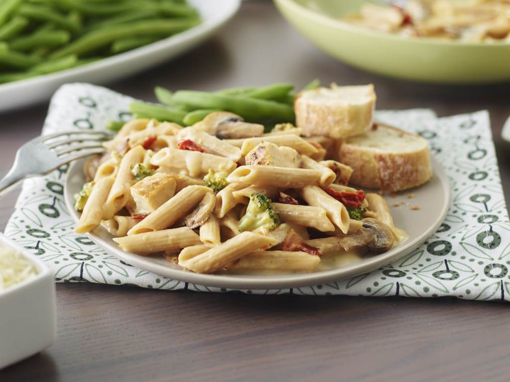 Cheesy Chicken Broccoli Pasta on a plate with slices of bread on the side